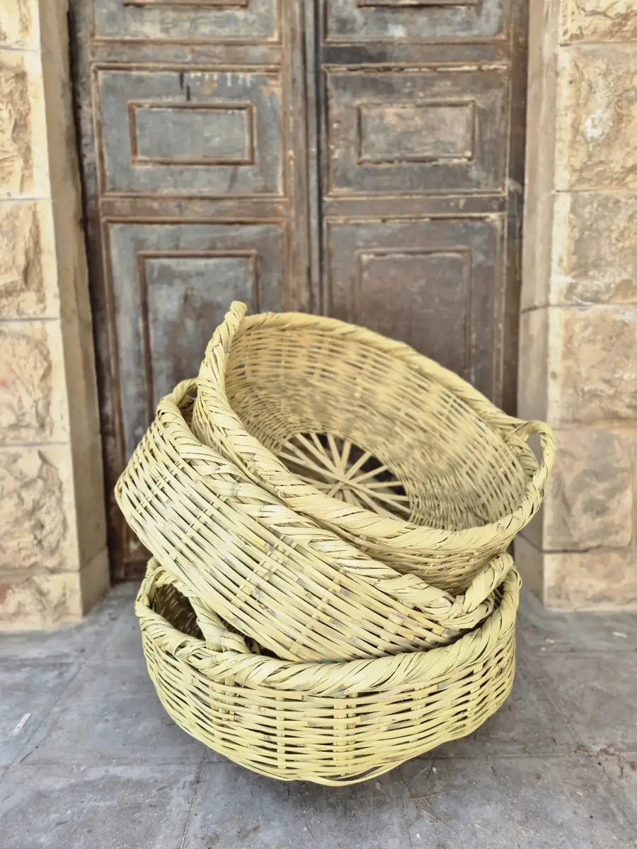 שלושה סלי מידונה מונחים זה על זה מול דלת עתיקה
